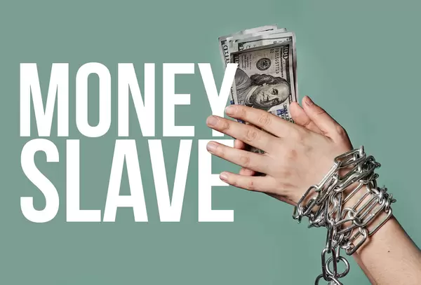 Money slave - business person hands chained holding money