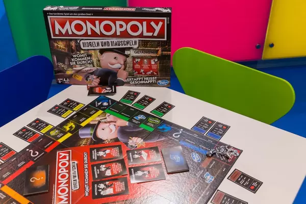 Monopoly Mogeln und Mauscheln ausgepackt auf dem Tisch spielbereit mit Spielkarton im Hintergrund
