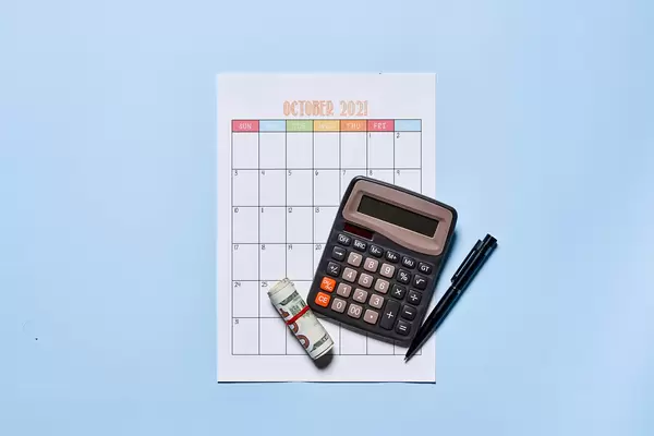 Monthly budget planning - money and calculator on the october monthly calendar