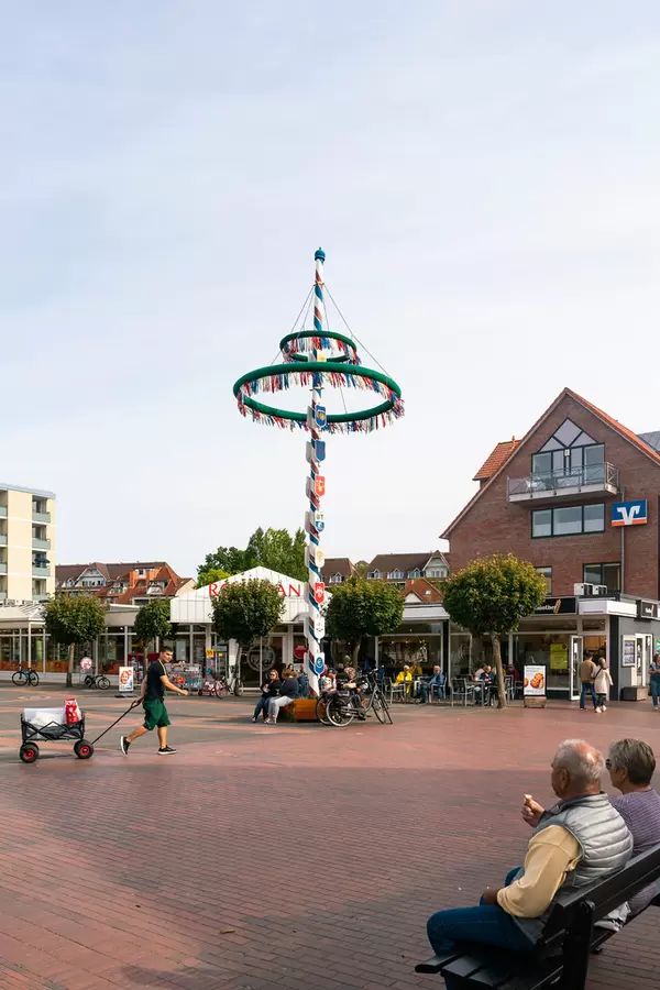 Monument of the Mast decorated with different flags in the city-center  of German resort town