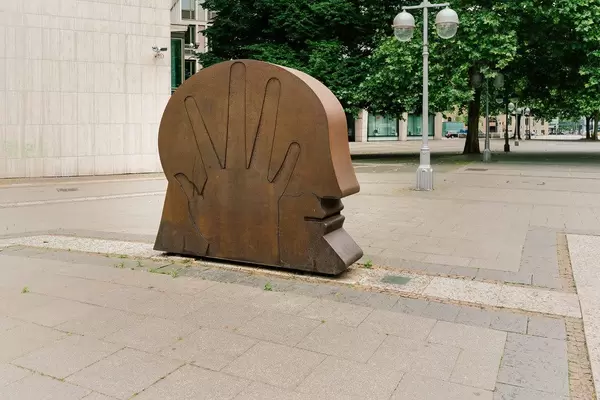 Monument with head and palm in the street of Hannover, Germany