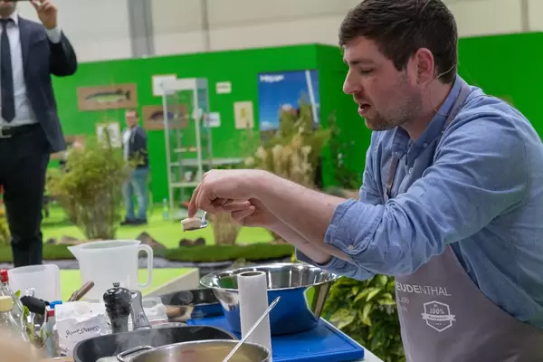 Moritz Freudenthal zeigt Zubereitung von Fischgericht an Messe