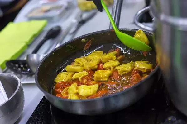 Mosna - frische gefüllte Pasta - vegane Bio Tortellini mit Tomatensoße werden zubereitet