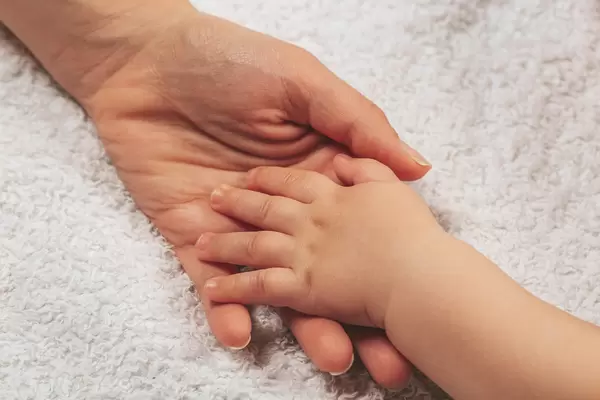 Mother's and baby's hands together