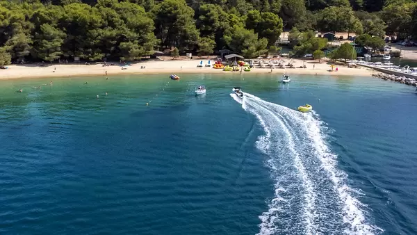 Motorboote und Aquadonuts vor dem Strand Chrysi Ammos auf Skiathos, Griechenland