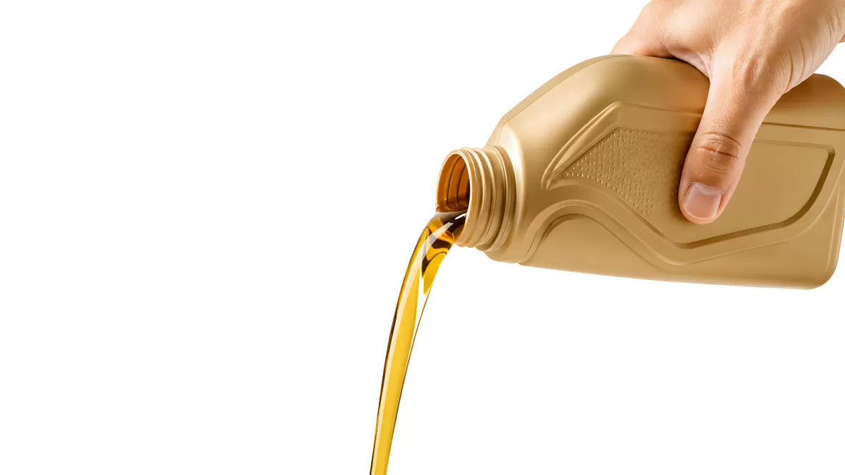 Motoröl wird aus goldener Kanne gegossen