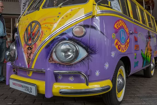 MotorWorld Oldtimer cars at IAA car show in Germany: Colorful retro VW T1 - Bus in new music loving design with Peace-Symbol and rock legend Jimi Hendrix