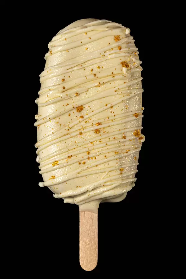Mousse dessert with white chocolate in the shape of ice cream on a stick, black background