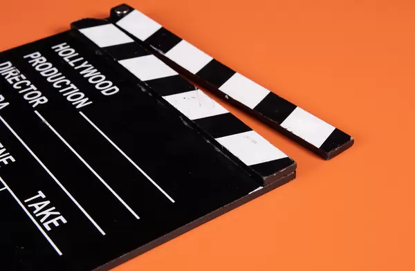 Movie clapper on orange background