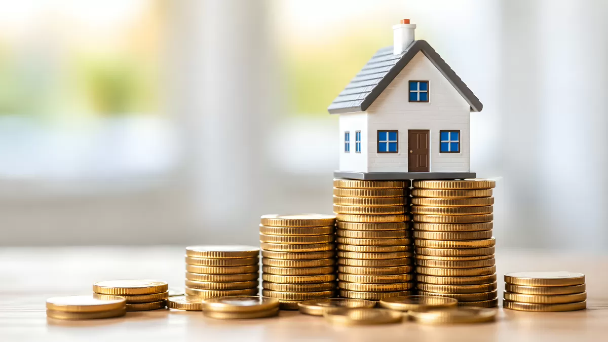Münzstapel mit Hausmodell – steigende Immobilienpreise