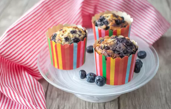 Muffins mit Blaubeeren in Muffinförmchen in Regenbogenfarben