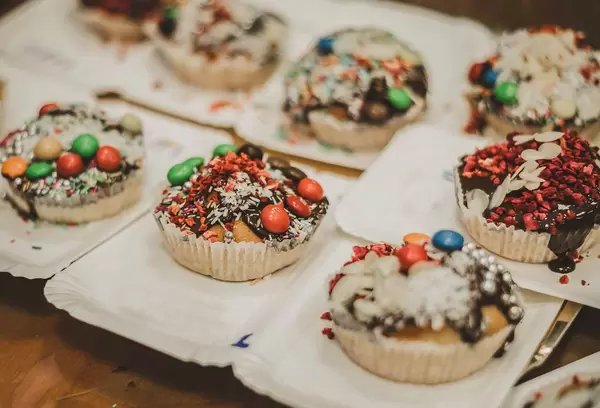 Muffins mit Schokoladeüberzug, M&Ms, Kokosstreusel und getrockneten Erdbeerstreuseln
