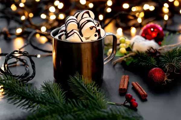 Mug with hot chocolate and marshmallows on a Christmas background with bokeh