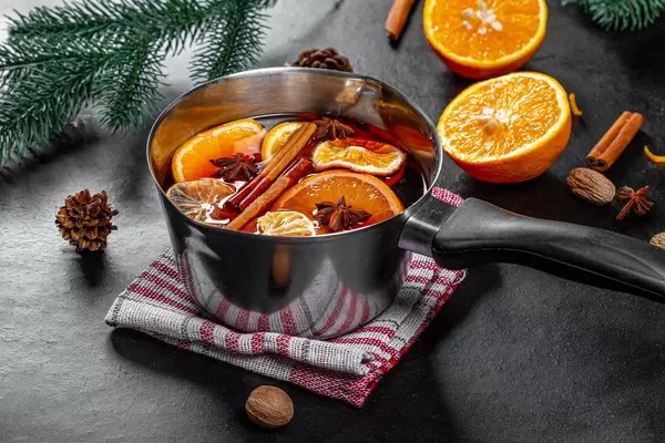Mulled wine with spices and slices of citrus fruits in a pan