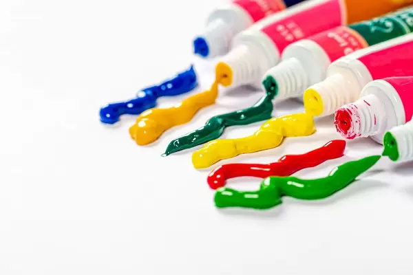 Multi-colored paint coming out of the tube on white background (Flip 2019)