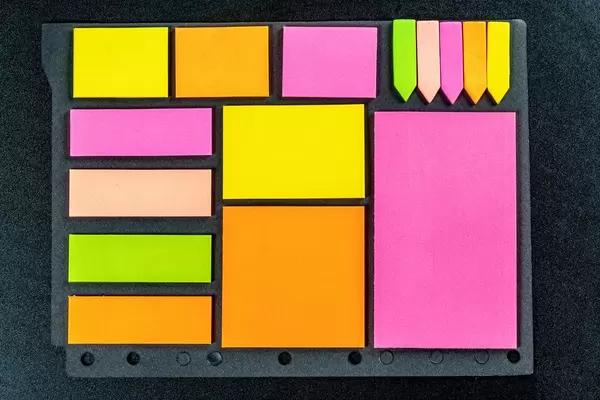 Multi-coloured stickers on black background, top view