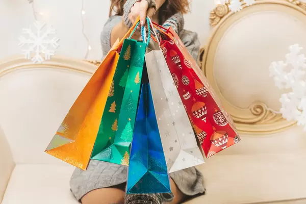 Multicolored bright gift bags in hand, close-up