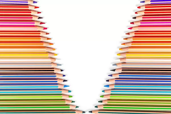 Multicolored colored pencils on white background with free space