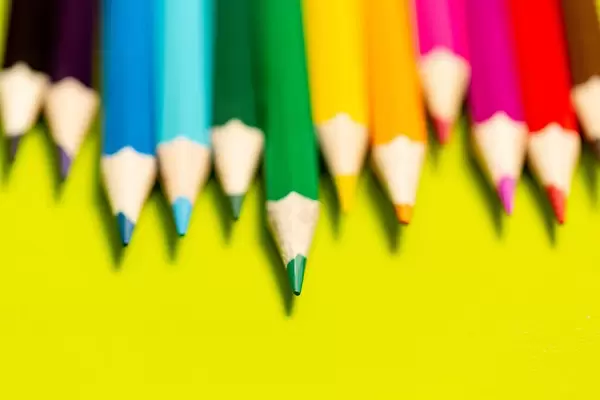 Multicolored pencils on a yellow