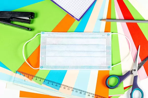 Multicolored school background with medical mask