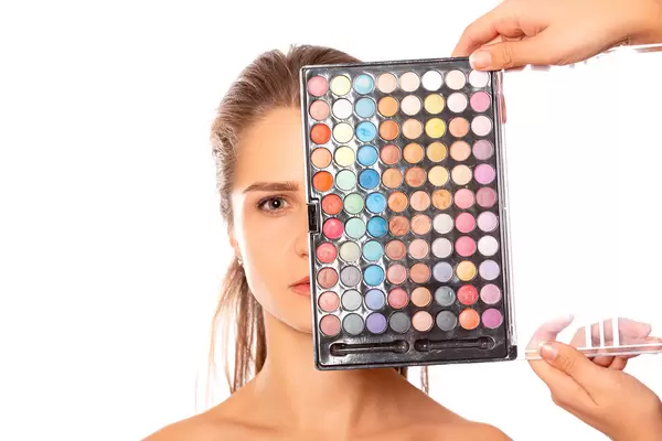Multicolored set of eyeshadows near the girl's face