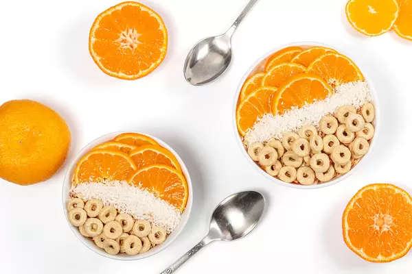 Multigrain breakfast with tangerines and coconut flakes, top view