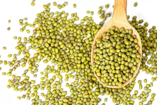 Mung beans in wooden spoon on white background (Flip 2020)