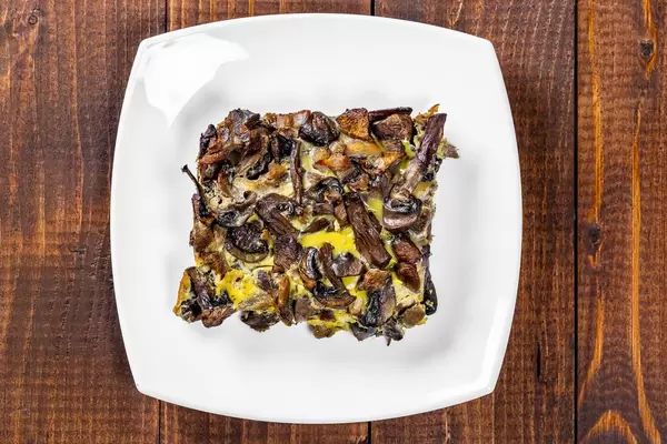 Mushroom gratin on a wooden background. Top view