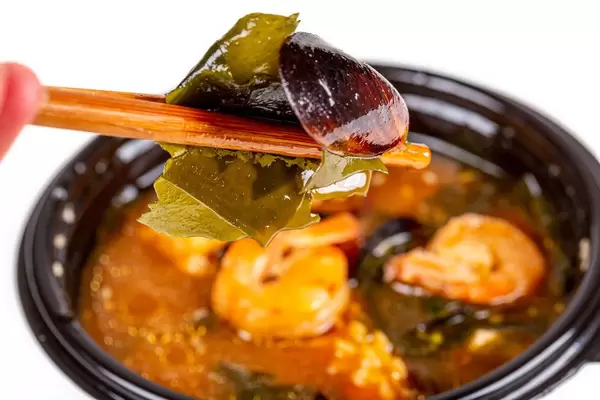 Mussels and wakame seaweed in wooden sticks, close-up