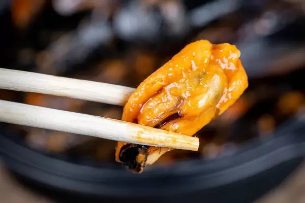 Mussels in tomato sauce with chopsticks, closeup