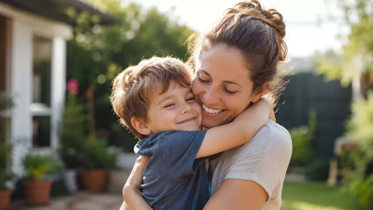 Mutter und Sohn umarmen sich herzlich im Garten