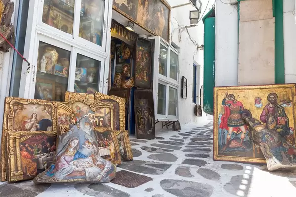 Mykonos, Griechenland: Kunstladen, der christliche Gemälde in einer Gasse verkauft