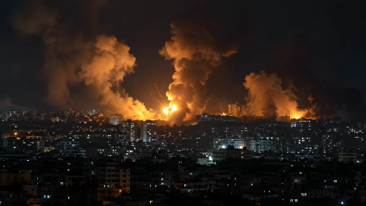 Nächtliche Explosionen und Feuersäulen über einer Stadt