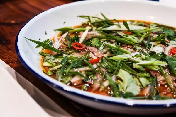 Nahansicht eines köstlichen Schweinegerichts mit Gemüse und Soße