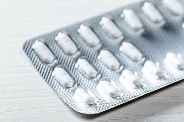 Nahaufnahme Blister-Packung mit weißen Tabletten zur medizinischen Behandlung auf Tisch