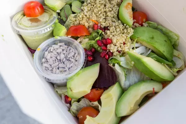Nahaufnahme des gemischten  Insalata QUINOA AVOCADO aus der L'Osteria, mit Granatapfel, Sonnenblumenkerne und Ruccola-Dressing