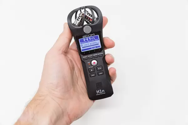 Nahaufnahme einer Hand, die den Handy-Recorder Zoom H1n hält. Zugriff auf SD Karte