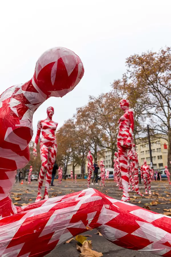 Nahaufnahme einer mit rot-weißem Absperrband umwickelten Schaufensterfigur am Neumarkt, Köln