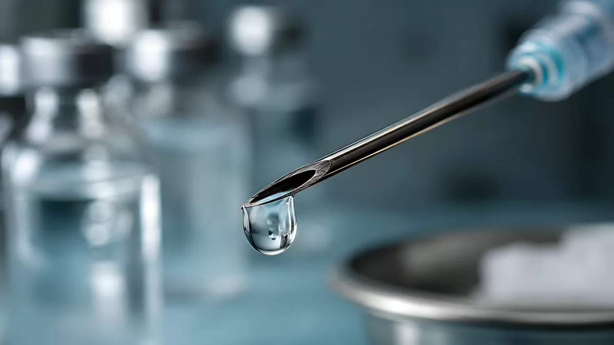 Nahaufnahme einer Spritzennadel mit Wassertropfen