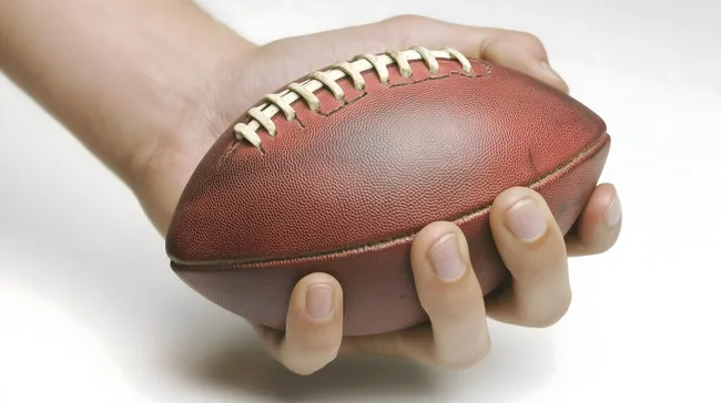 Nahaufnahme eines amerikanischen Footballs in Händen