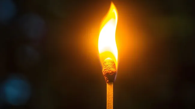 Nahaufnahme eines brennenden Streichholzes mit heller Flamme