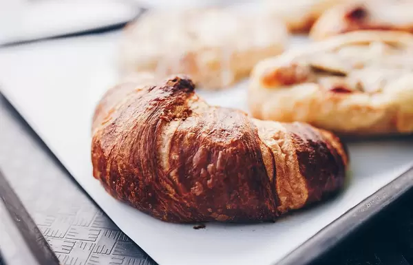 Nahaufnahme eines Croissants mit Butter. Schnelles Frühstück