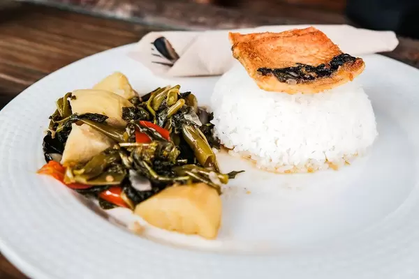 Nahaufnahme eines Gerichts mit Milchfisch, Gemüse und Reis