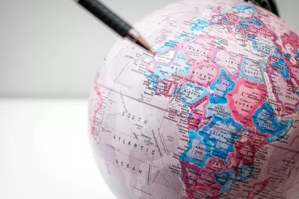 Nahaufnahme eines Globus mit Stift im Vordergrund