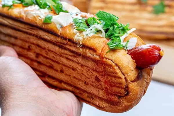 Nahaufnahme eines Hotdogs in einer Frauenhand