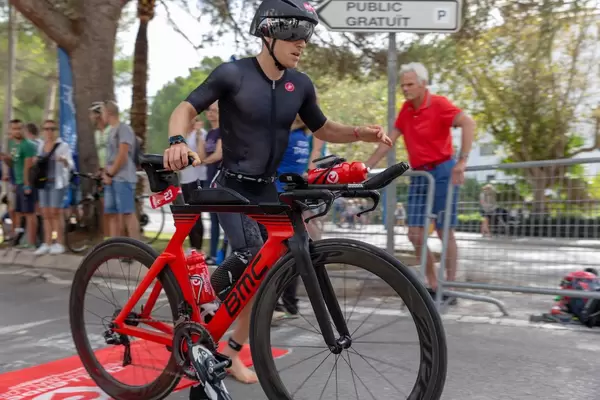 Nahaufnahme eines Mannes in schwarzer Bekleidung nimmt Anlauf um sich auf sein Rad bei einem Triathlon zu schwingen - Paguera Challenge Triathlon 2018