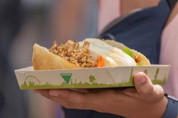 Nahaufnahme eines Sandwichs mit Hühnchen auf kompostierbarem Teller am Tomorrowland Festival 2019