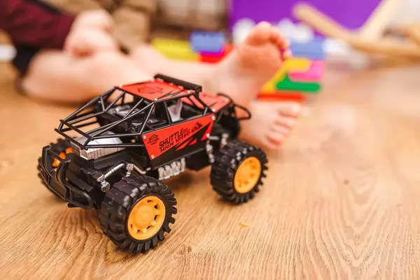 Nahaufnahme eines Spielzeugautos mit Kind im Hintergrund