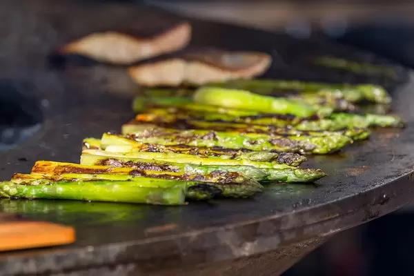 Nahaufnahme gegrillter grüner Spargel auf Grillplatte am 15. Tomorrowland Festival 2019 in Belgien