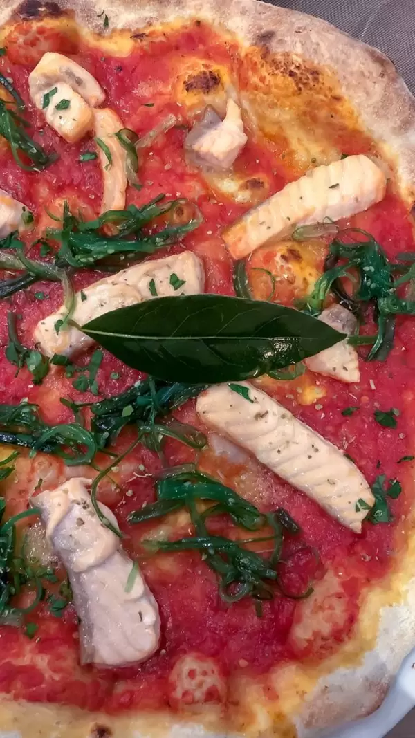 Nahaufnahme gesunde Pizza mit Fischstücken und dem Superfood Algen